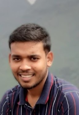 Close-up portrait of a smiling person wearing a striped shirt, set against a blurred background.