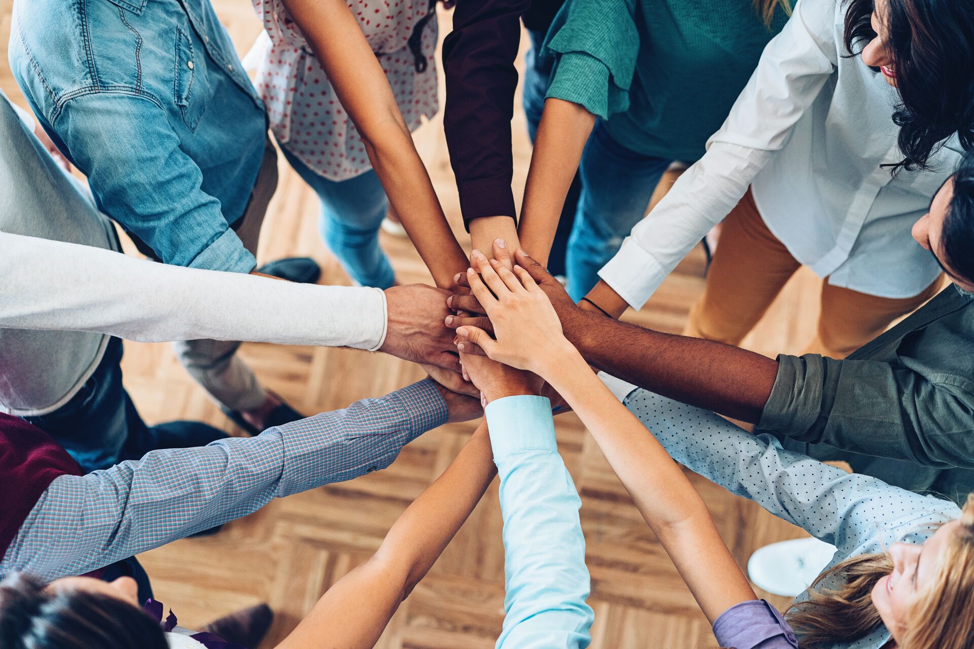 Group of people putting hands together in the middle