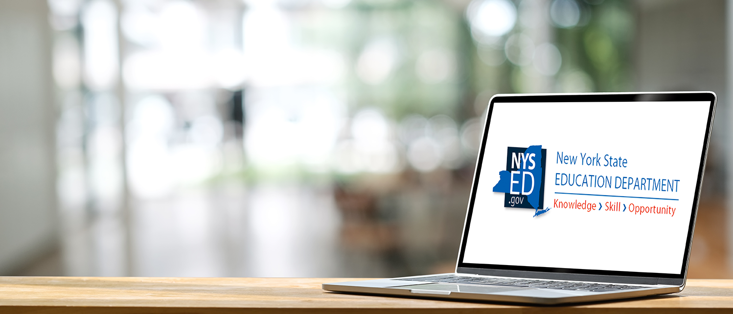 A laptop on a wooden desk. NYSED logo is on the screen.