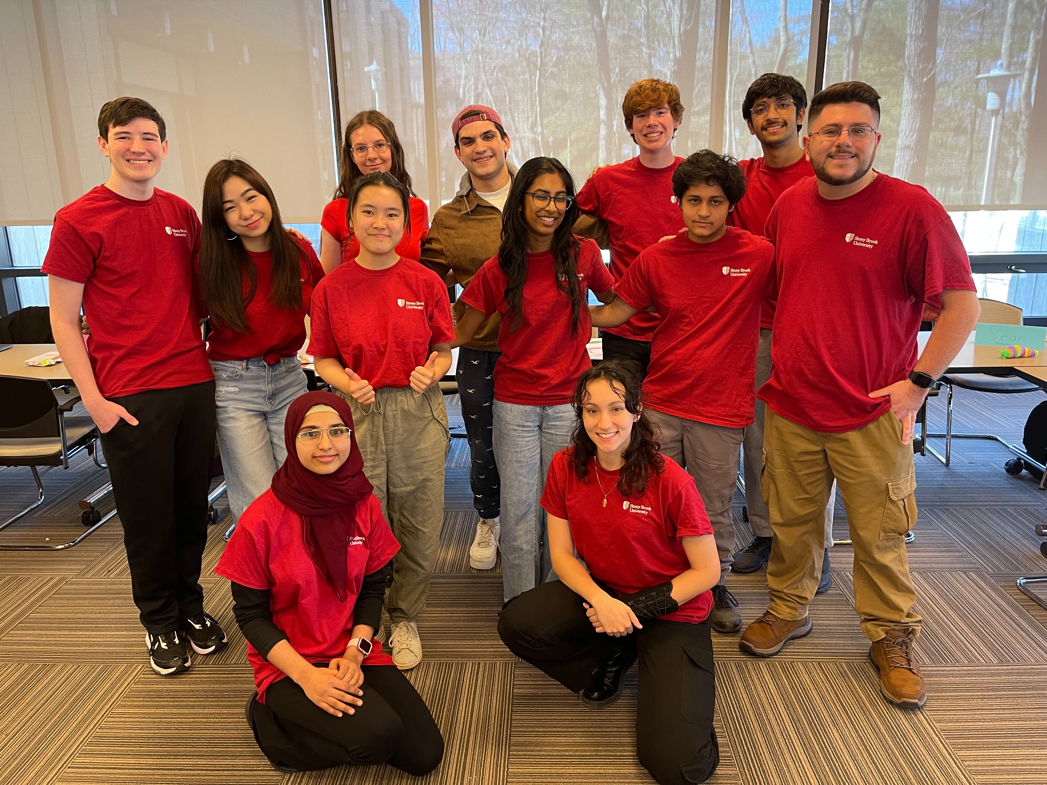 University Scholars pictured in their University Scholars t-shirts smiling with their arms around each other.